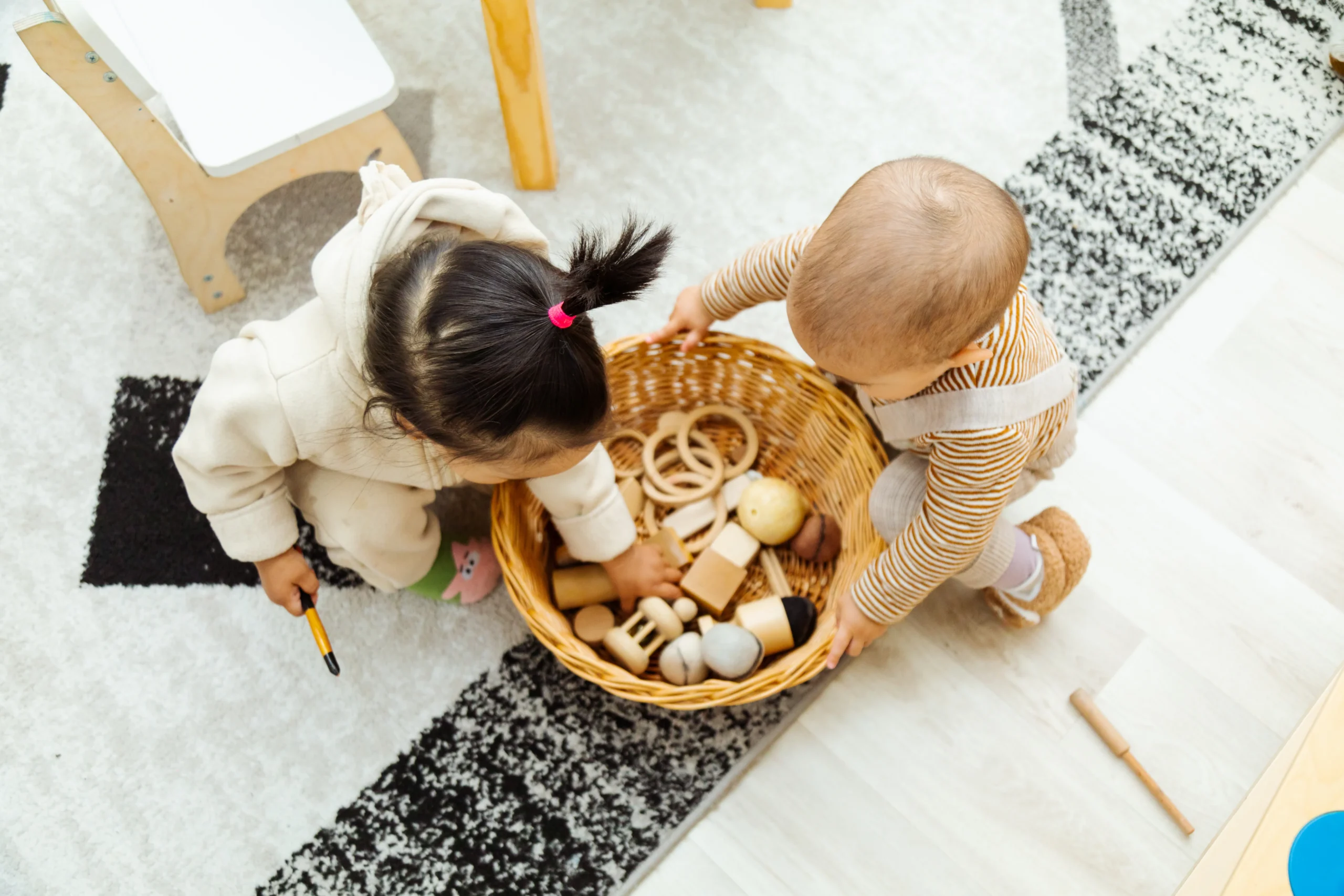 two-infants-playing-with-wooden-toys-indoors-2026-03-25-00-30-00-utc